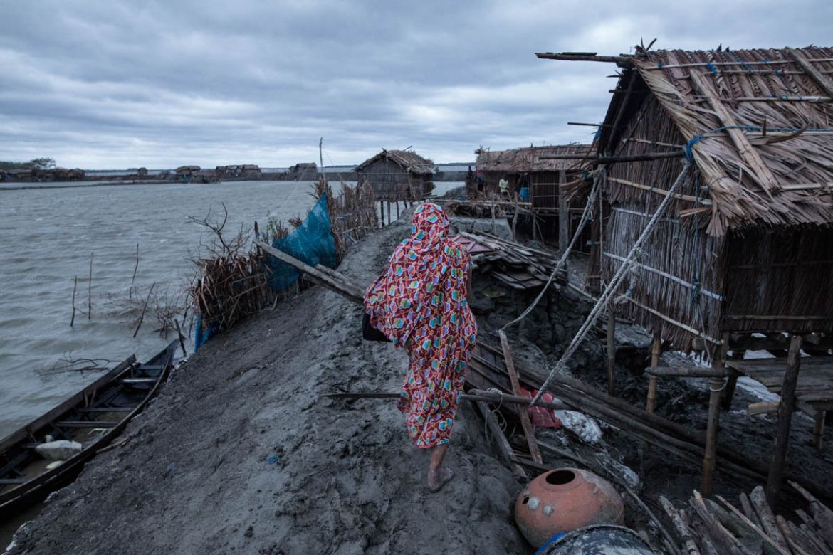 A women return home just after the storm in a coastal area of Bangladesh. 17 people were killed in ten districts of the country, as a number of houses collapsed and trees were felled by gusts in the l