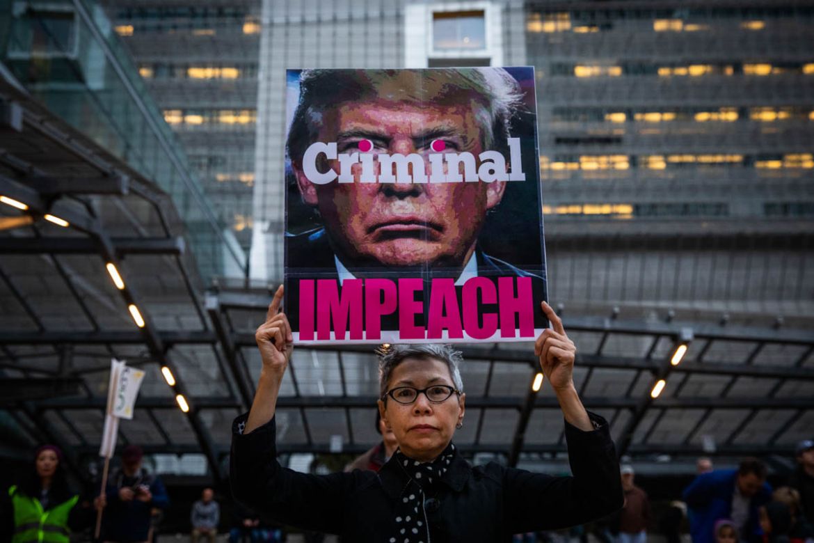 Connie Jeung-Mills of San Francisco holds a sign during a demonstration in part of a national impeachment rally, at the Federal Building in San Francisco, California on December 17, 2019. Protesters a