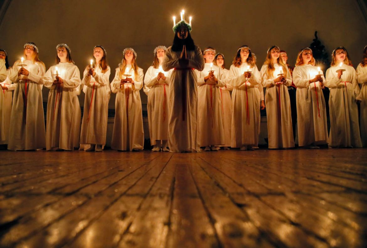 Young women sing carols as they hold candles to celebrate St. Lucia''s Day in the Evangelical Lutheran Church of Saint Katarina in St.Petersburg, Russia, Friday, Dec. 13, 2019. The Church was built in