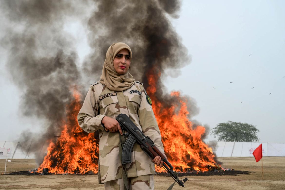 A soldier from Pakistan''s Anti-Narcotics Force (ANF) stands beside a burning pile of seized drugs set on fire during a drug burning ceremony in Lahore on December 11, 2019.  ARIF ALI / AFP