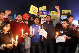 Demonstrators holding candles and placards shout slogans during a protest against a new citizenship law and to show solidarity with the students of New Delhi''s Jamia Millia Islamia university after po