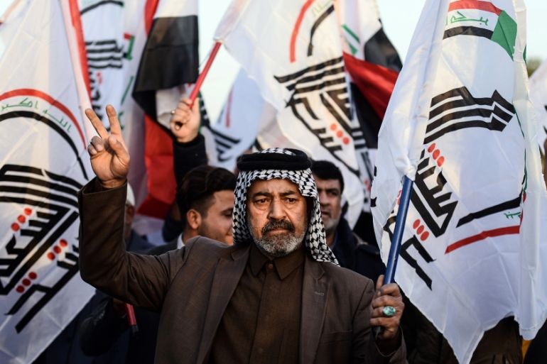 Iraqis wave Hashed Al-shaabi armed network flags on December 30, 2019, during a demonstration in holy shrine city of Najaf to denounce the previous night''s attacks by US planes on several bases belong