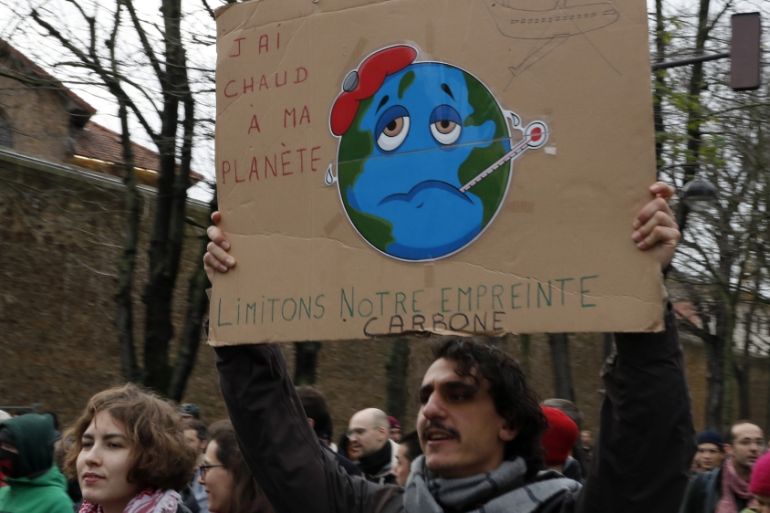 Protestors holding a cardboard reading "I am hot for my planet, limit the carbon print" take part of a climate change protest march calling for the U.N. COP 25 climate talks in Madrid, to address clim