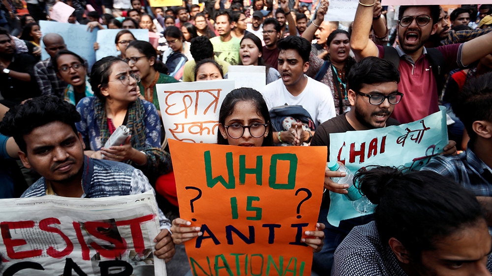 Students hold placards and shout slogans in solidarity with Jamia Millia Islamia university students after police entered the campus on the previous day in New Delhi, following a protest against a new