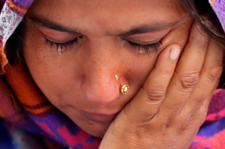 A woman weeps as she waits outside a mortuary to receive the body of her relative who died in a fire that swept through a factory where laborers were sleeping, in New Delhi