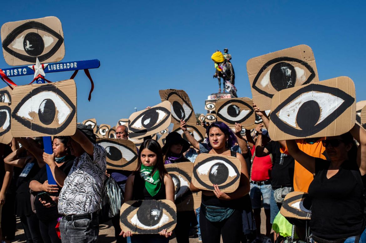 Demonstrators hold placards depicting eyes -in reference to police pellets reaching demonstrators'' eyes- during a protest against Pinera''s government in Santiago, on December 10, 2019. Pinera promisse