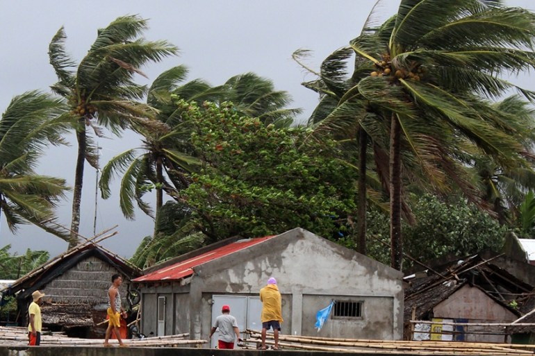 Villagers view strong winds blow trees next to houses in the town of Calabanga, Camarines sur province, Philippines, 02 December 2019. According to the latest government weather bureau forecast, a typ