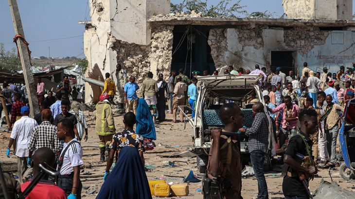 Somali people gather at a car bombing attack site in Mogadishu, on December 28, 2019. - A massive car bomb exploded in a busy area of Mogadishu on December 28, 2019, leaving at least 76 people dead, m