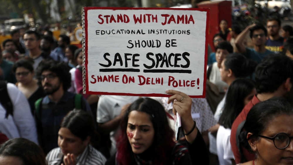 A woman holds a placard during a protest in solidarity with Jamia Millia Islamia university students after police entered the campus on Sunday in New Delhi, following a protest against a new citizensh