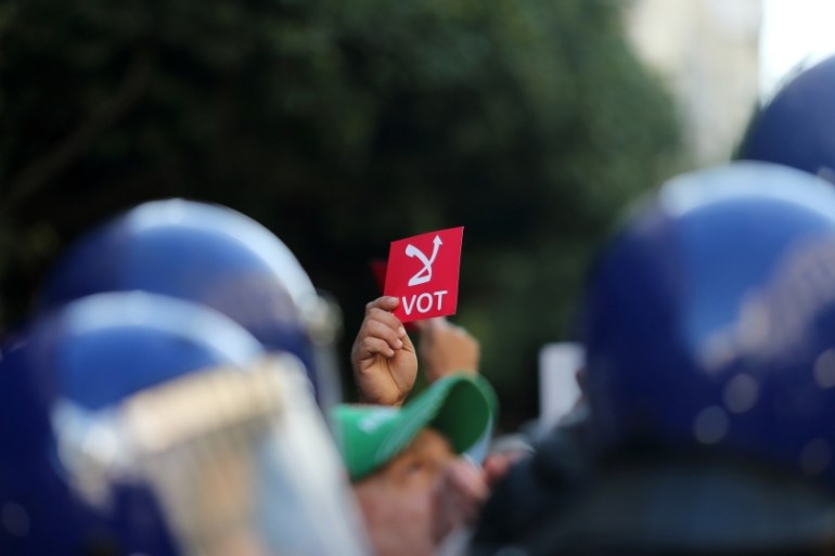 A demonstrator holds a sign reading "No vote", during a protest rejecting the presidential election in Algiers