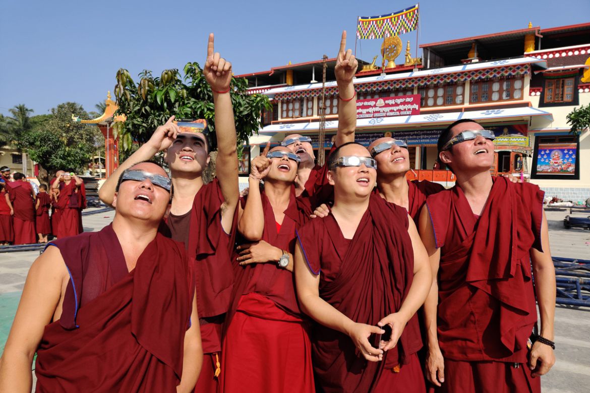 Monks wearing solar filter glasses watch a "ring of fire" solar eclipse at the Gaden monastery in a Tibetan colony in Teginkoppa, 50km south of Dharwad in India''s southern Karnataka state, on December