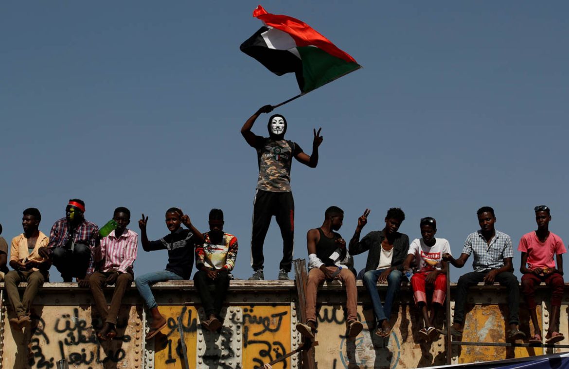 A Sudanese protester wearing a Guy Fawkes mask waves a national flag outside the defence ministry compound in Khartoum, Sudan, April 24, 2019. REUTERS/Umit Bektas TPX IMAGES OF THE DAY