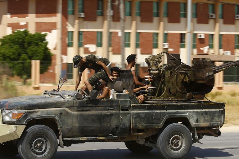 Fighters loyal to the UN-recognised Government of National Accord (GNA), geare transported on board of a military vehicle during clashes with forces loyal to strongman Khalifa Haftar, in Espiaa, abou