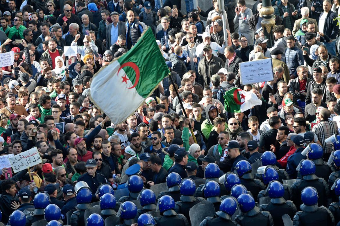 Algerian security surround protesters during an anti-government demonstration in the capital Algiers on December 11, 2019, ahead of the presidential vote scheduled for December 12. Algeria''s contentio