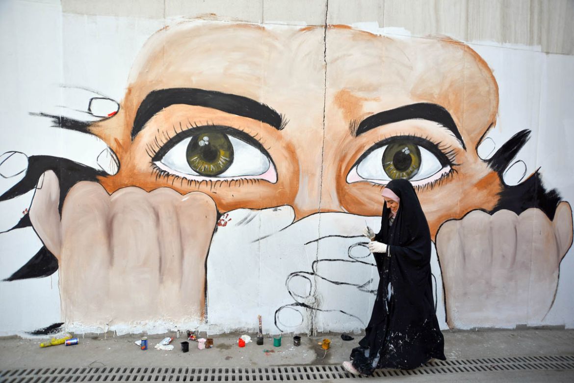 An Iraqi protester puts the final touches on a mural painting amid ongoing anti-government demonstrations in the central city of Najaf on December 18, 2019.  Haidar HAMDANI / AFP