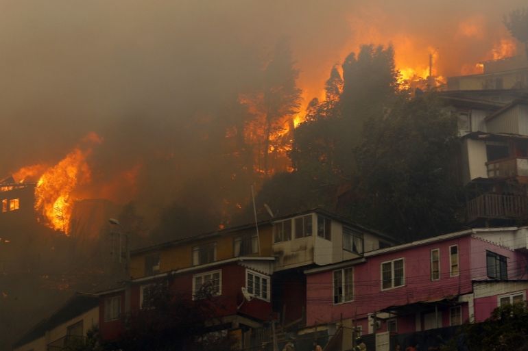 Houses burn during a forest fire at the Rocuant hill in Valparaiso, Chile, on December 24, 2019. Some 50 houses were affected by a forest fire Tuesday in Valparaiso, where a red alert was declared. R