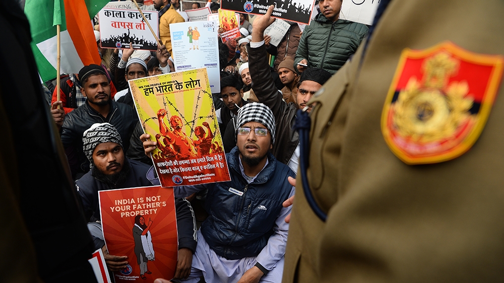 A policeman confronts protesters gathered for a demonstration against Indiai´s new citizenship law in New Delhi on December 19, 2019. - Big rallies are expected across India on December 19 as the tumu