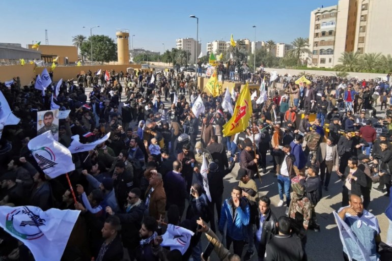 Protesters and militia fighters gather to condemn air strikes on bases belonging to Hashd al-Shaabi (paramilitary forces), outside the main gate of the U.S. Embassy in Baghdad, Iraq December 31, 2019.