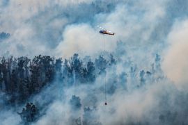 This handout photo taken on December 29, 2019 and received on December 30 from Victoria''s Department of Environment, Land, Water and Planning (DELWP) shows a helicopter dumping water on a fire in Vict