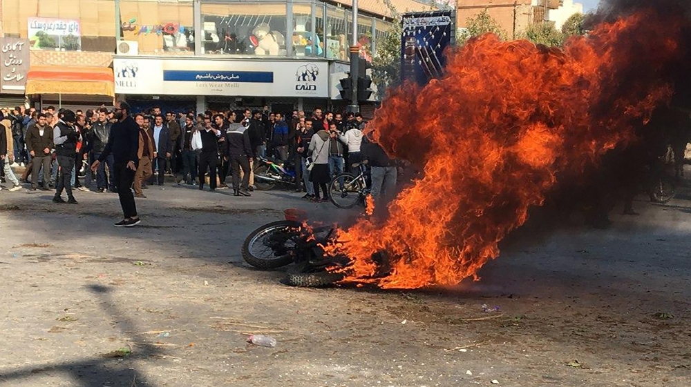 Iranian protesters gather around a burning motorcycle during a demonstration against an increase in gasoline prices in the central city of Isfahan, on November 16, 2019. [AFP]
