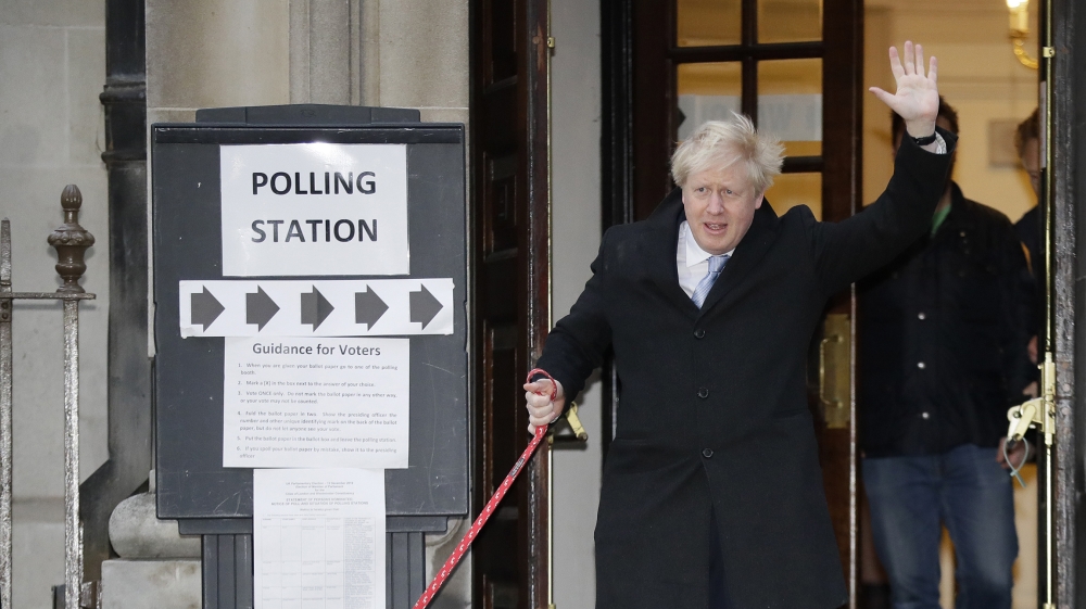 Britain's Prime Minister and Conservative Party leader Boris Johnson with his dog Dilyn leaves after voting in the general election at Methodist Central Hall, Westminster, London, Thursday, Dec. 12, 2