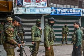 Security personnel stand near the site of a grenade blast at a market place outside the campus of Kashmir''s main university in Srinagar on November 26, 2019. - At least two people were killed in grena