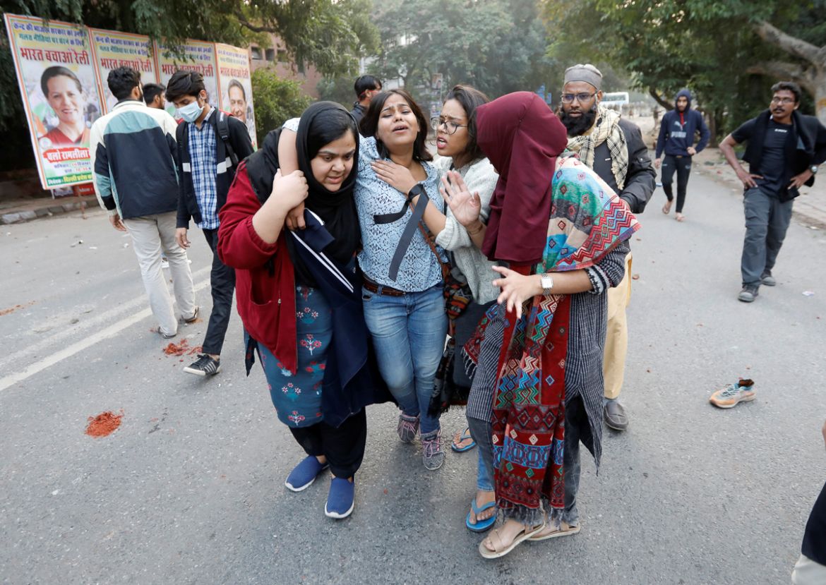 A woman is helped after she was injured during a protest against a new citizenship law, in New Delhi, India, December 15, 2019. REUTERS/Adnan Abidi
