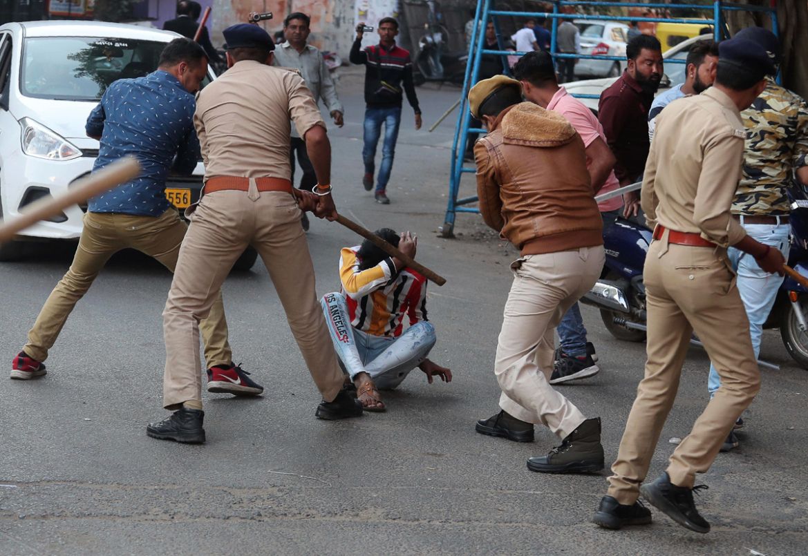 Indian policemen baton charge a man during a protest against a new citizenship law in Ahmadabad, India, Thursday, Dec. 19, 2019. Police detained several hundred protesters in some of India''s biggest c
