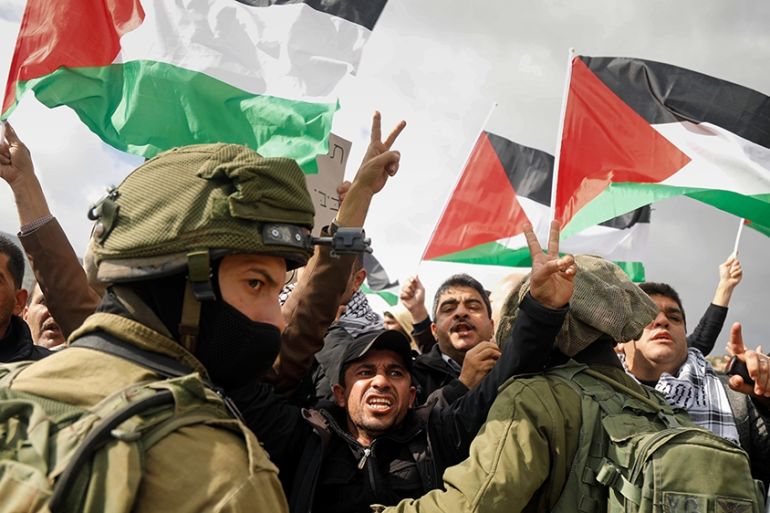Palestinian demonstrators gesture in front of Israeli forces during a protest against the U.S. president Donald TrumpO~s Middle East peace plan, in Jordan Valley in the Israeli-occupied West Bank Janu