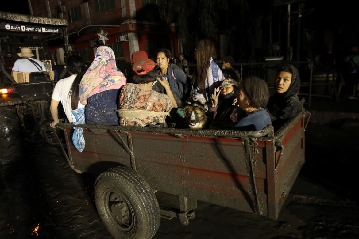 Villagers ride a tractor after a volcano eruption in Talisay, Batangas, Philippines, 13 January 2020. Thousands of people have been ordered to evacuate as authorities in the Philippines raised the ale