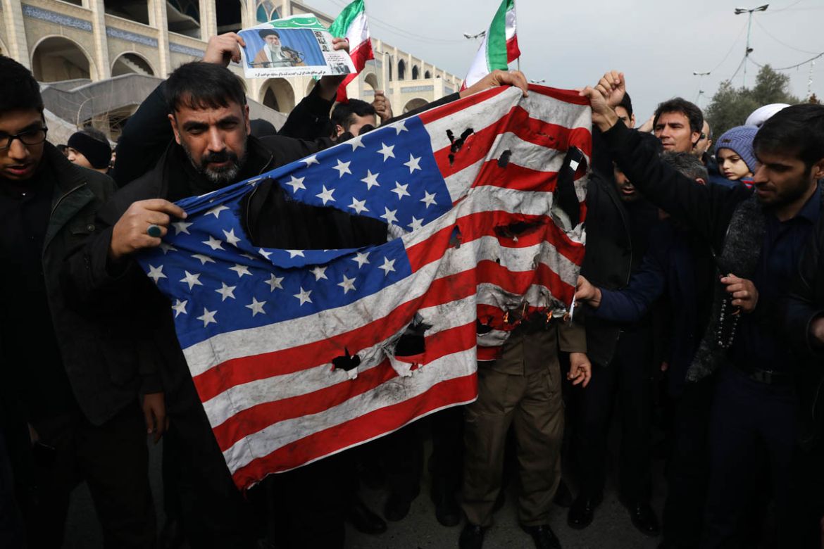 Protesters burn a U.S. flag during a demonstration over the U.S. airstrike in Iraq that killed Iranian Revolutionary Guard Gen. Qassem Soleimani, in Tehran, Iran, Jan. 3, 2020. Iran has vowed "harsh r