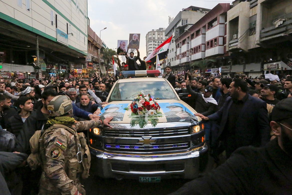 Mourners surround a car carrying the coffins of Iranian military commander Qasem Soleimani and Iraqi paramilitary chief Abu Mahdi al-Muhandis, killed in a US air strike, during their funeral processio