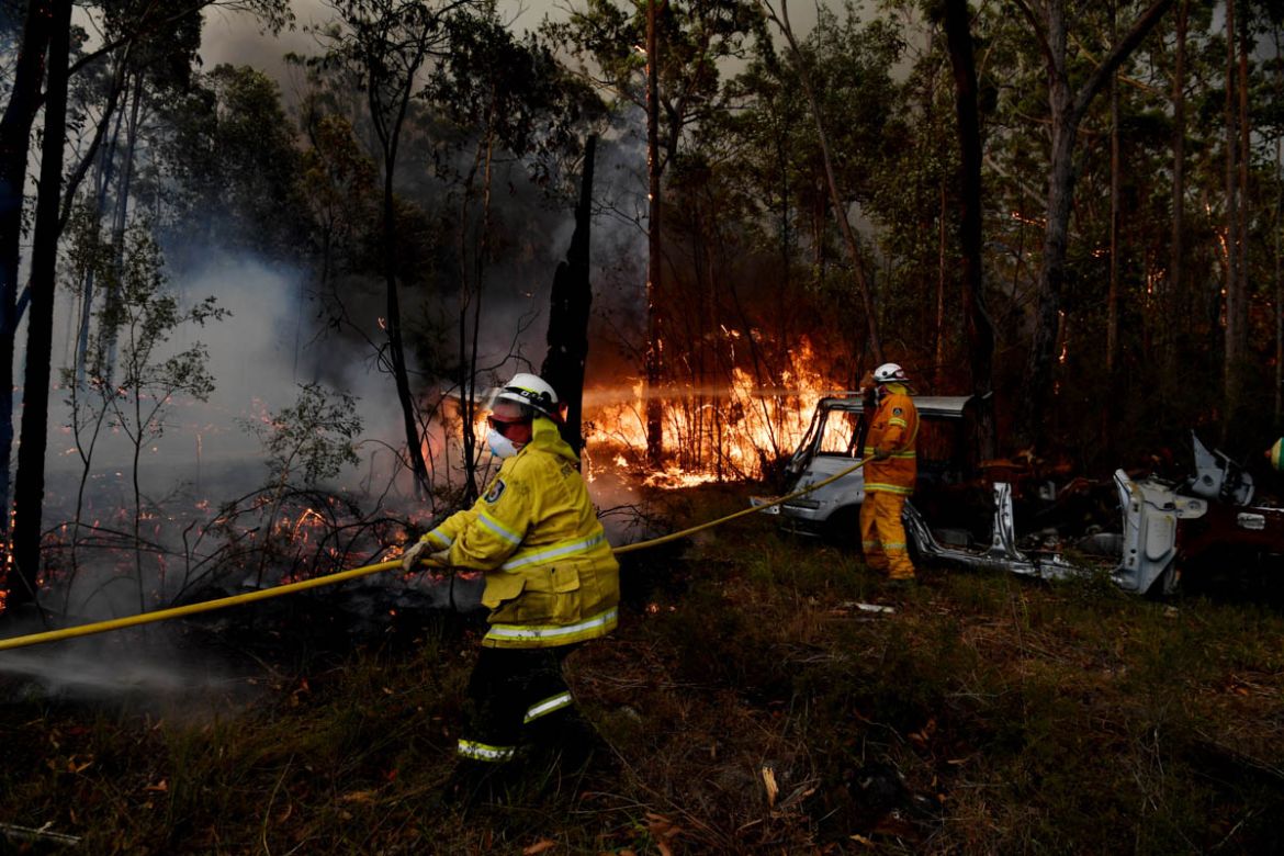 SYDNEY, AUSTRALIA - DECEMBER 31: Rural Fire Service (RFS) firefighters conduct property protection near the town of Sussex Inlet on December 31, 2019 in Sydney, Australia. There are a number of danger