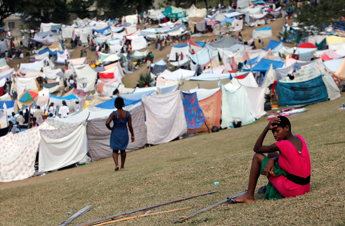 A woman sits in a makeshift camp for earthquake survivors near a country club used as a forward operating base for the U.S. 82nd Airborne Division in Port-au-Prince, Haiti, Saturday, Jan. 16, 2010. (A