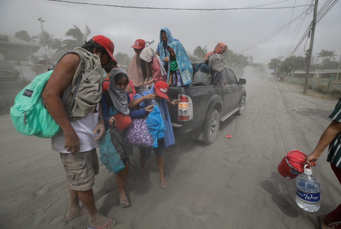 A family evacuates to safer grounds as Taal volcano in Tagaytay, Cavite province, southern Philippines on Monday, Jan. 13, 2020. (AP Photo/Aaron Favila)