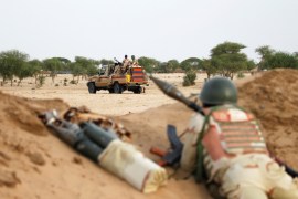 Niger soldiers guard with their weapons pointed towards the border with neighbouring Nigeria, near the town of Diffa
