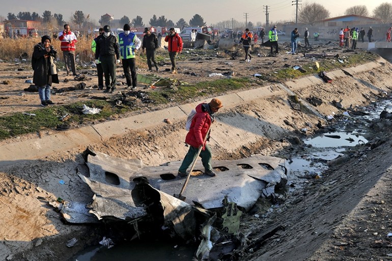 Rescue workers inspect the scene where a Ukrainian plane crashed in Shahedshahr, southwest of the capital Tehran, Iran, Wednesday, Jan. 8, 2020. A Ukrainian airplane with more than 170 people crashed