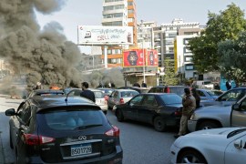 Cars are stuck in a traffic jam as Lebanese anti-government protesters block a road with burning tires during a demonstration in Beirut on January 14, 2020.
