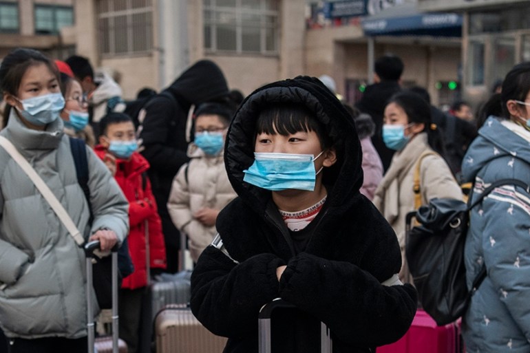 Chinese children wear protective masks as they wait to board trains at Beijing Railway station before the annual Spring Festival on January 21, 2020 in Beijing, China. The number of cases of a deadly