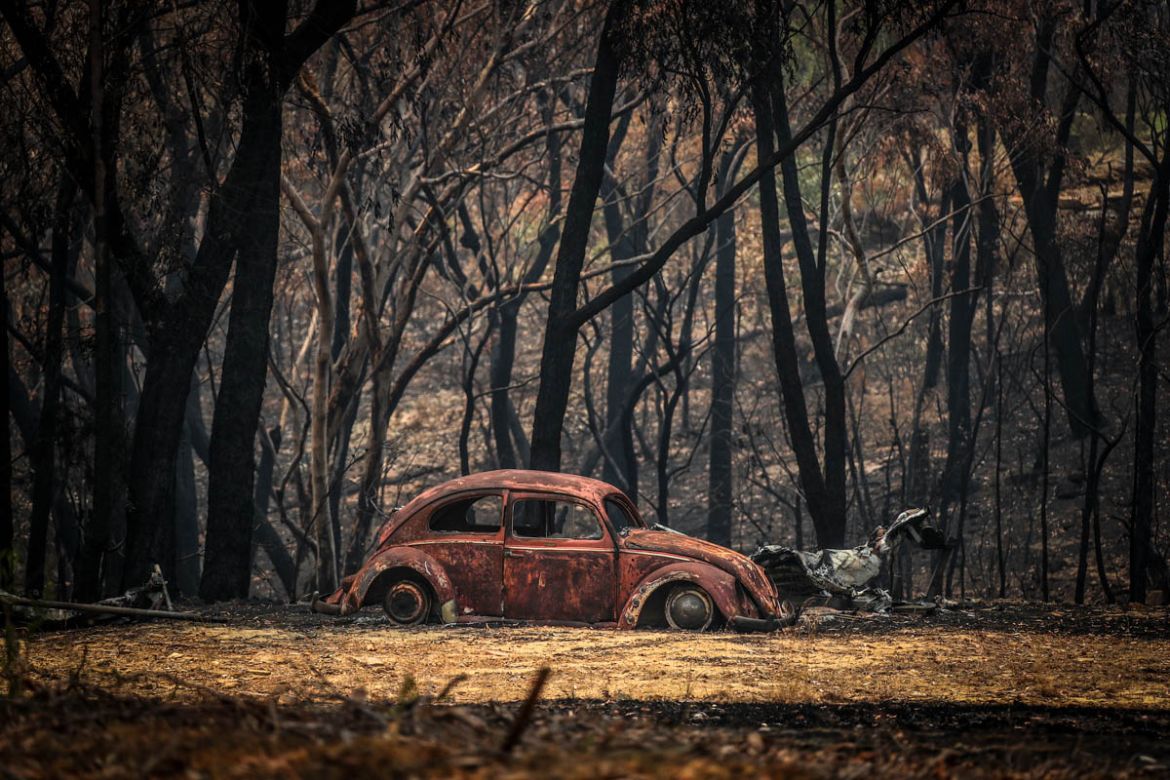SYDNEY, AUSTRALIA - DECEMBER 30: The remains of a car that was destroyed by bushfires sits near a home in the town of Balmoral on December 30, 2019 in Sydney, Australia. Firefighters have made the mos