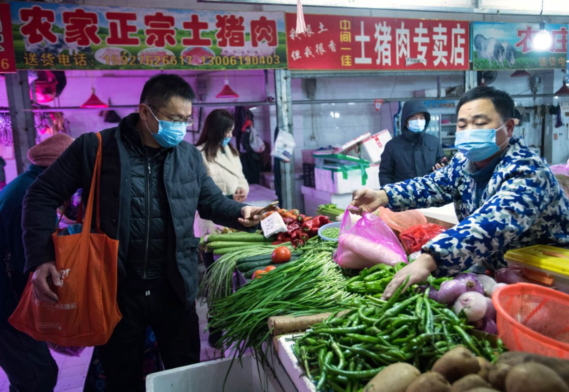 In this photo released by China''s Xinhua News Agency, people shop for vegetables at a market in Wuhan in central China''s Hubei Province, early Thursday, Jan. 23, 2020. China closed off a city of more