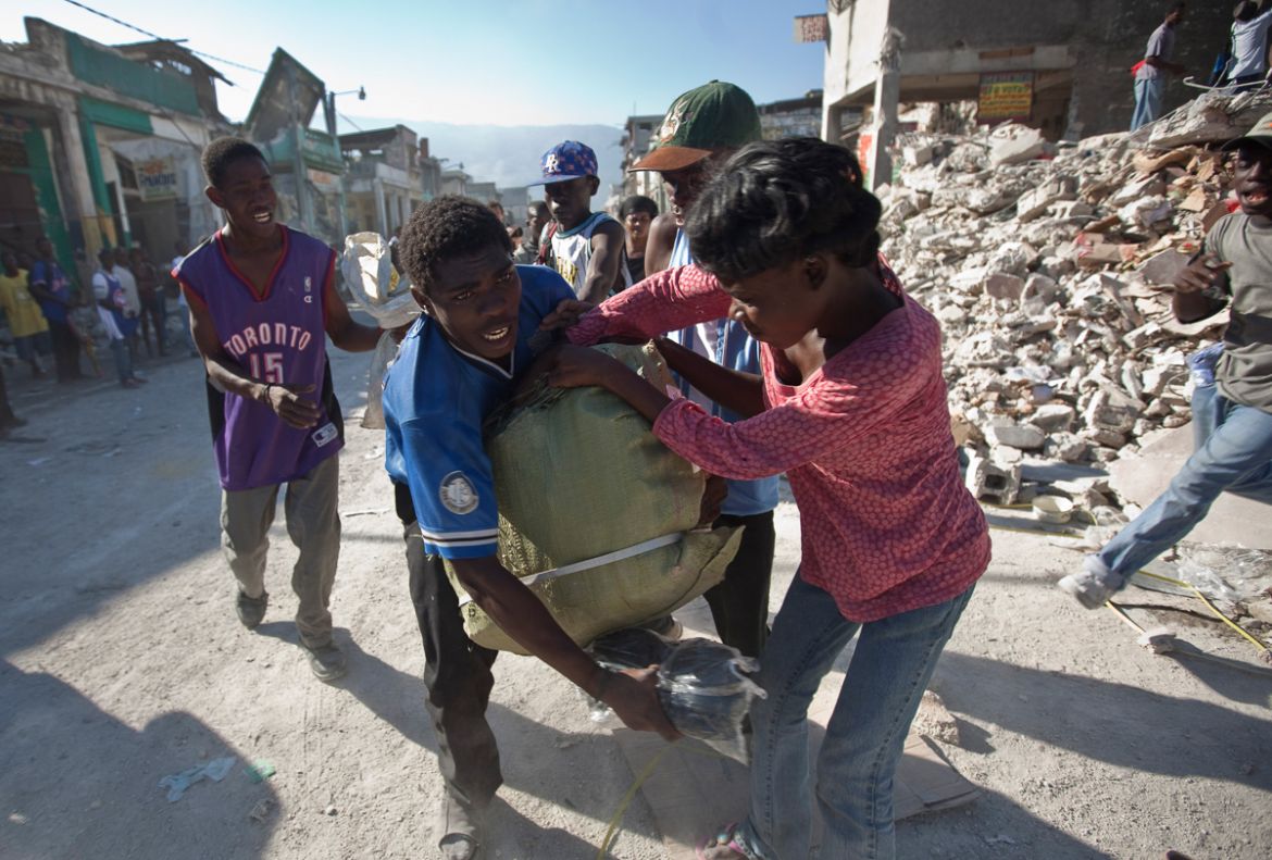 People fight over goods scavenged from the rubble in Port-au-Prince, Friday, Jan. 15, 2010. A powerful earthquake struck Haiti on Tuesday. (AP Photo/Ramon Espinosa)