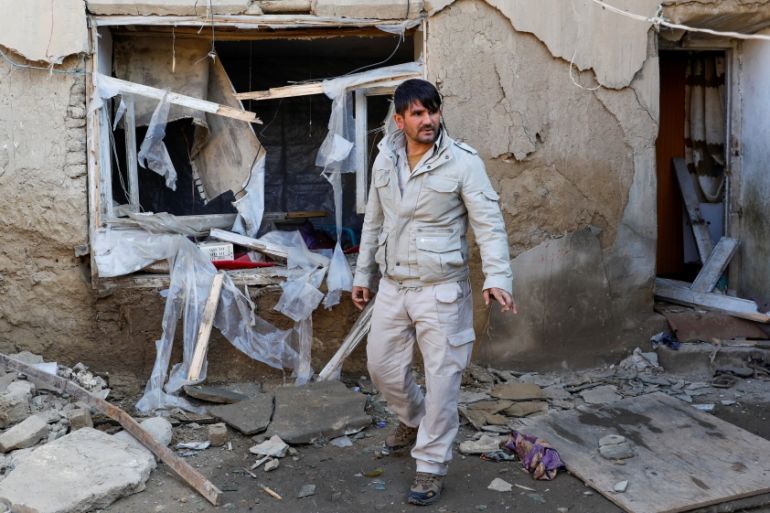 A man inspects a damaged house at the site of an attack in a U.S. military air base in Bagram