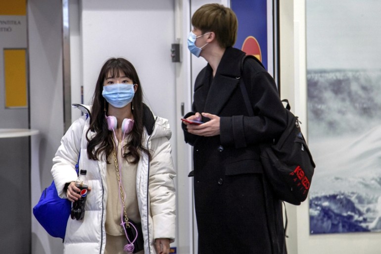 Air travellers wear masks as they arrive at Ivalo Airport, Finland January 24, 2020. On Thursday, two tourists visiting Finland from Wuhan, China went to a health centre in Ivalo, seeking treatment fo