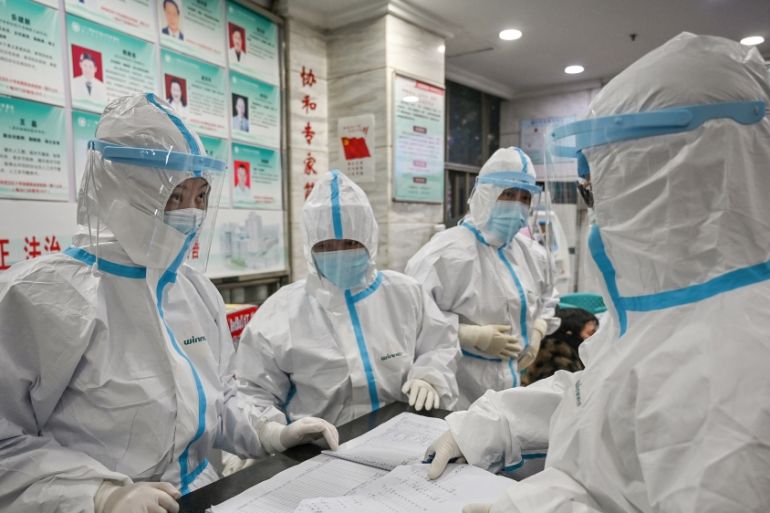 Medical staff members wearing protective clothing to help stop the spread of a deadly virus which began in the city, work at the Wuhan Red Cross Hospital in Wuhan on January 25, 2020. - The Chinese ar
