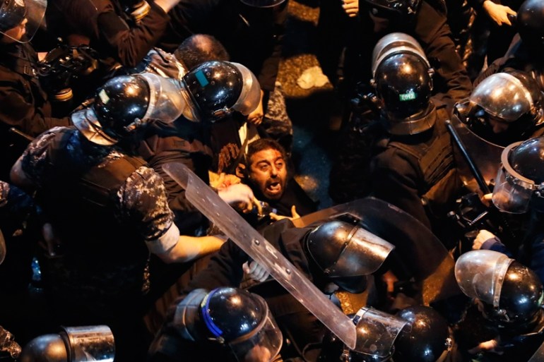Riot police arrest an anti-government protester who was protesting outside a police headquarters demanding the release of those taken into custody the night before, outside a police headquarter, in Be