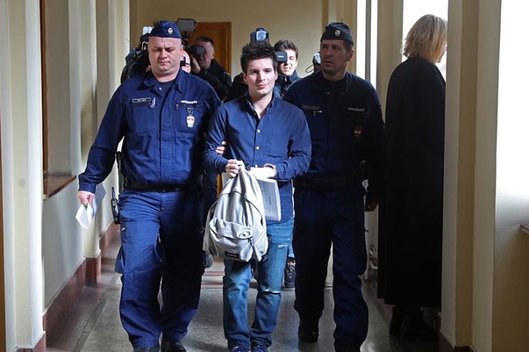 (FILES) In this file photo taken on March 5, 2019 Football Leaks whistleblower Rui Pinto (C) is escorted by judicial officers as he arrives at the Metropolitan Court in Budapest, Hungary, for his tria