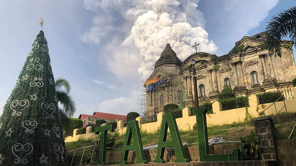 This handout photo taken and received on January 12, 2020 courtesy of Renz Lejarso Guevara shows ash from the Taal volcano (not pictured) in the air, as seen against a church in the foreground in the 