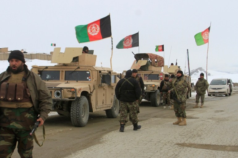 Afghan National Army forces go towards the site of an airplane crash in Deh Yak district of Ghazni province