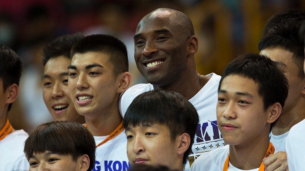 Los Angeles Lakers NBA star Kobe Bryant poses with fans for pictures while attending a youth basketball final match in Hong Kong August 3, 2013. Bryant kicks off his China tour in Hong Kong, where he 